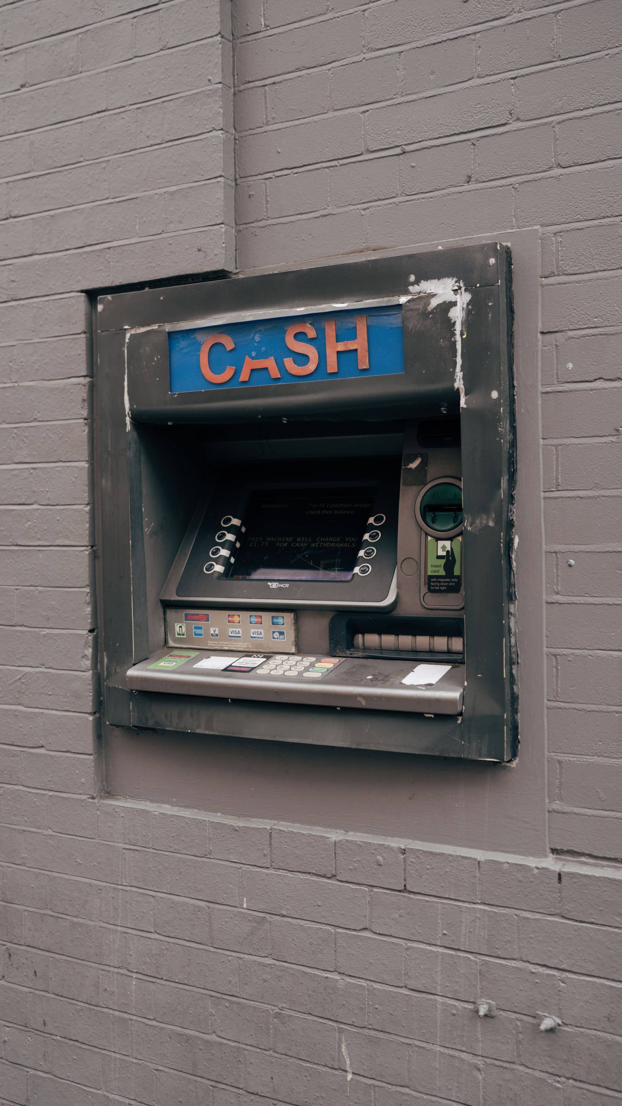 A cash machine set into a gray brick wall