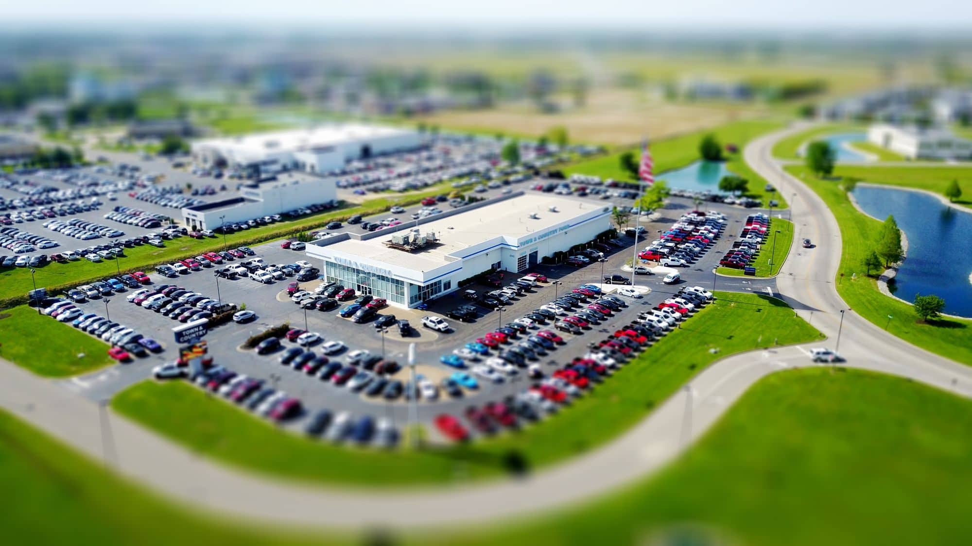 Aerial view of a car dealership with rows of vehicles in its lot